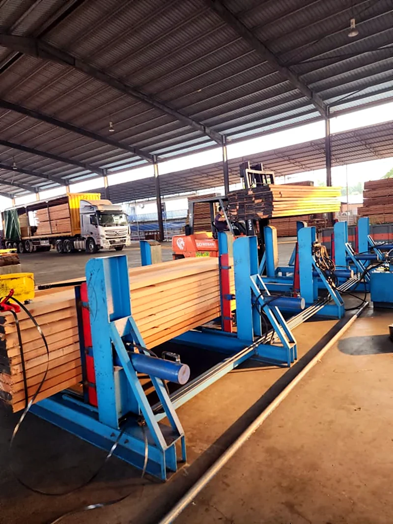 Sawn timber on the processing line at the Dowlet warehouse, with a loaded truck and forklift behind
