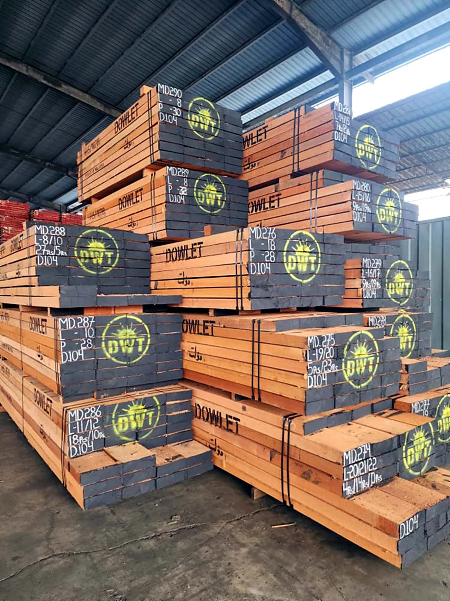 Dowlet-branded sawn timber bundles stacked in a covered warehouse, ready for export